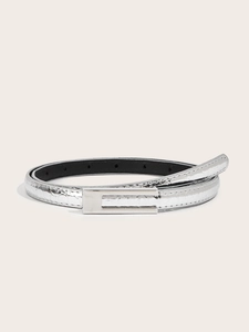 Close-up of a slim silver belt featuring an embossed crocodile texture and a metal buckle