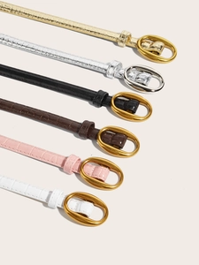 Close-up showing six assorted crocodile pattern slim belts with chic oval metal buckles