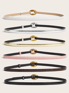 Detailed view of six thin women's faux leather belts with elegant crocodile patterns