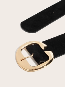 Vue détaillée de la ceinture large en daim noir avec une grande boucle en métal doré