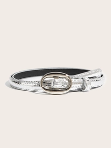 Detail of silver women belt with faux crocodile texture and oval polished buckle