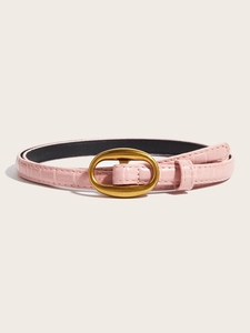 Detail of light pink slim leather belt featuring a gold oval buckle and crocodile texture