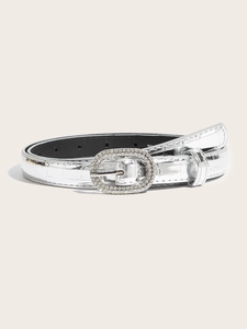 Detail of silver crocodile-embossed belt with crystal-studded oval buckle