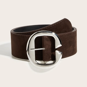 Détail d'une large ceinture en daim marron foncé avec grande boucle en métal argenté en C