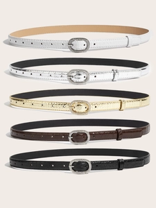 Detail of slim faux leather belts with crocodile texture and rhinestone oval buckles