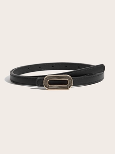 Détail d'une fine ceinture noire avec boucle ovale dorée vintage au fini gaufré à pois