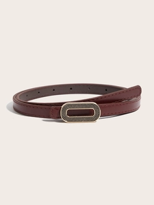 Détail d'une ceinture fine bordeaux avec une boucle dorée ovale à texture perlée