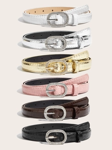 Detail view of thin faux leather belts with crocodile texture and rhinestone oval buckles