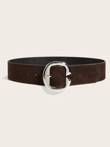 Détail de ceinture en daim marron foncé avec une grande boucle métallique en C argentée
