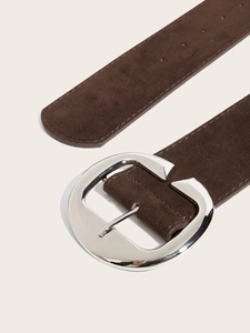 Détail d'une large ceinture en daim marron café avec boucle en métal argenté poli