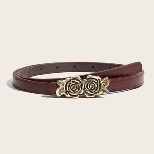 Ceinture fine en similicuir rouge foncé avec boucle double rose dorée sur fond beige