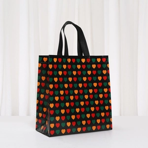 Detail of waterproof non-woven tote bag with colorful heart patterns and sturdy handles