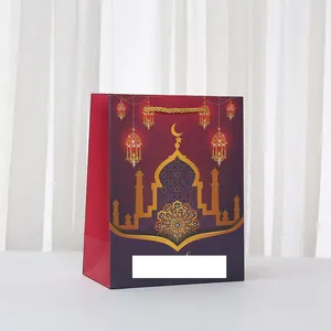 Détail d'un sac cadeau en papier avec motifs de mosquées dorées et anses tressées chic