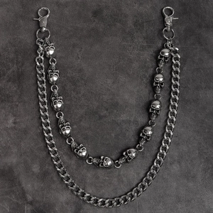 Detail of punk style double-layered skull chain with vintage silver finish on rock background