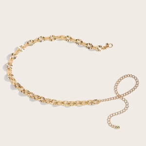 Detailed close-up of a gold metal waist chain with textured rings and lobster clasp