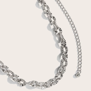 Detail of silver metal hollow chain with radial texture rings and adjustable length