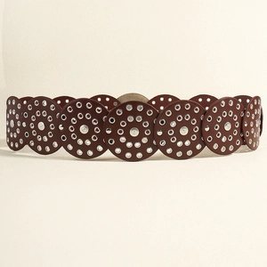 Detail of vintage brown wide leather belt with metallic grommet circles in western style