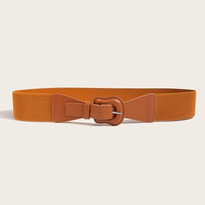 Detail of orange-brown elastic waist belt featuring a silver metal buckle and leather patch