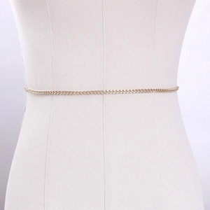 Dettaglio dell'elegante catena in metallo dorato con design a maglie sottili su manichino