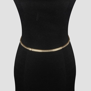 Macro detail of gold-plated V-shaped body chain with sparkling white rhinestones inlay