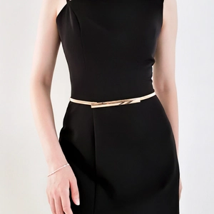 Close-up of minimalist gold metal waist belt with rectangular buckle on black dress