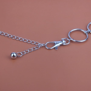 Minimalist silver metal body chain with circular ring and lobster clasp on peach background