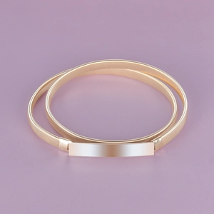 Detailed macro view of gold elastic spring belt with a flat rectangular buckle on purple background
