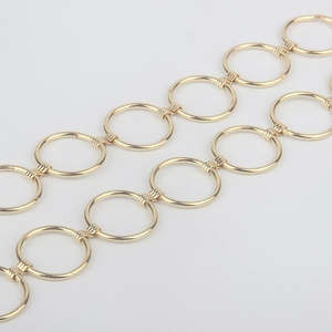 Close-up of golden metal round ring chain belt with polished mirror finish and buckles