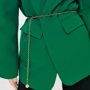 Minimalistische Goldmetall-Ketten-Gürtel mit rundem Anhänger auf grünem Blazer