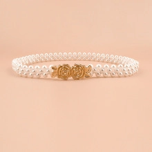 Close-up of pearl waist belt with double golden rose buckles for elegant dress styling