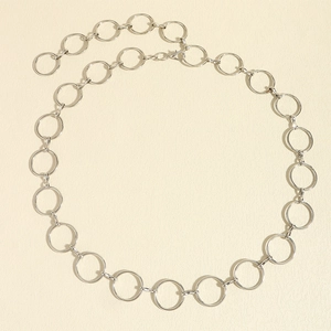 Detail of silver metal chain belt featuring circular rings and lobster clasp closure