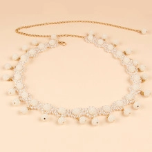 Close-up of elegant white pearl beaded belt with gold adjustable chain for dresses