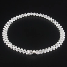 Detailed view of elegant triple-row white pearl choker with a silver bow buckle fastener