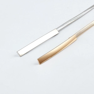 Detail of gold and silver thin elastic metal belts with minimalist rectangular buckle