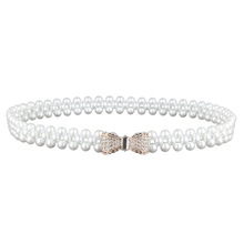 Detail of elegant bow buckle with rhinestones on a double-layer pearl elastic belt