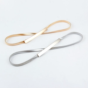 Detail of gold and silver elastic metal belts with minimalist rectangular buckles