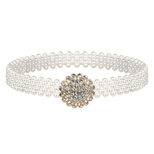 Detailed macro view of elastic pearl waist belt featuring a rhinestone flower buckle
