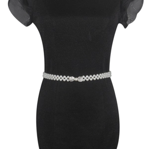 Close-up of triple-strand pearl waist belt with sparkling rhinestone bow buckle detail