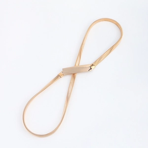Macro detail of slim gold metal snake chain elastic belt with polished buckle