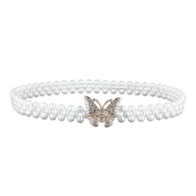 Detail of three-row pearl belt featuring a sparkling rhinestone bow buckle decoration