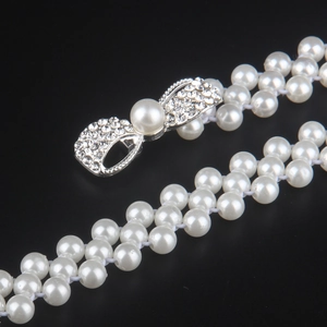Elegant double-row pearl waist belt featuring a sparkling rhinestone bow buckle decoration