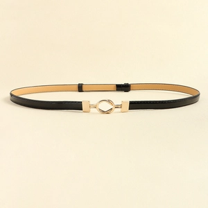 Detailed close-up of slim black PU leather belt with a knot-shaped gold metal buckle