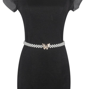 Detail of elegant pearl waist belt with rhinestone butterfly buckle on a black dress