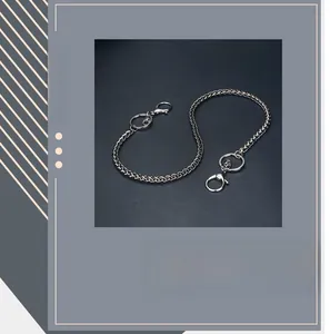 Dettaglio catena per pantaloni intrecciata in metallo argento con chiusura a moschettone
