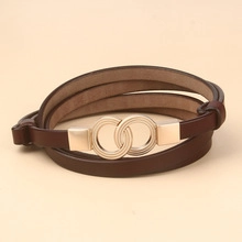 Close-up of thin brown leather belt with elegant golden double ring buckle