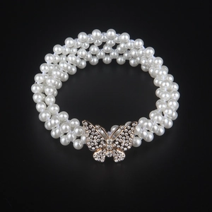 Detailed close-up of triple-layer pearl elastic belt featuring a golden rhinestone butterfly