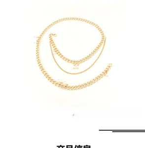 Detail of layered gold metal chain belt featuring elegant white pearl accents on white background