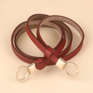 Macro detail of the wine red leather belt with decorative gold alloy double ring buckle