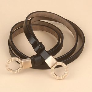Close-up of thin black leather belt featuring double golden ring buckles and fine texture
