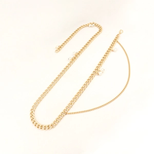 Golden multi-layer Cuban link waist chain for women with elegant pearl accents on white background